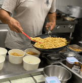 Cozinheiro preparando um prato para servir aos clientes